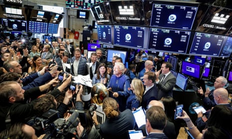 surrounded by a throng of journalists on the floor of the  New York Stock Exchange