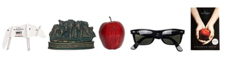 From left to right: a wolf-shaped cardboard knicknack, a metallic knicknack, a prop apple, sunglasses, and a twilight book