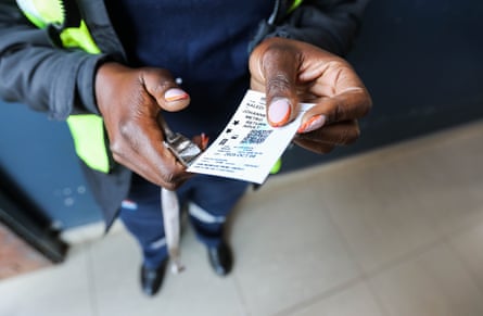 A Johannesburg Metrorail ticket inspector validates a train ticket.
