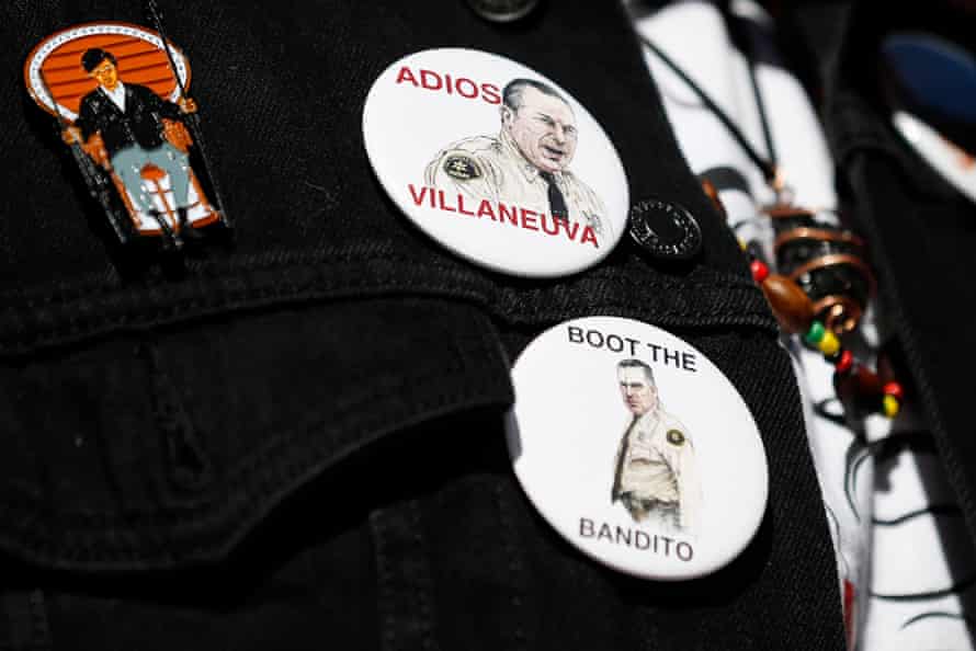 Pins on a person's shirt bear likenesses of Alex Villanueva with the words 'Adios Villanueva' and 'Boot the bandito'.