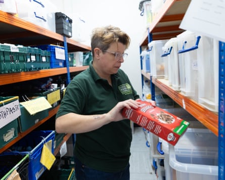 A volunteer holding cereal at Whitstable food bank