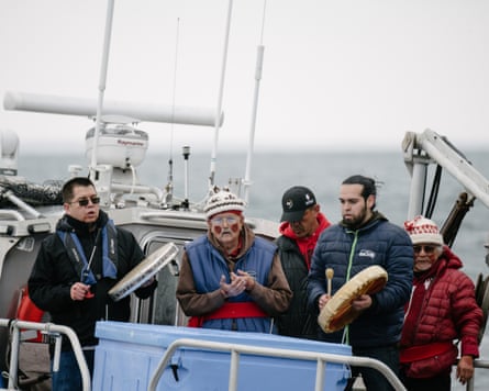 Lawrence Solomon, Secretary of the Lummi Business Council, Bill James, hereditary chief, Jeremiah Julius, Lummi Tribal Chairman, Tony Hillaire, Chief of Staff of the Lummi Nation Business Council and tribal leader Al Johnnie finish the ceremonial feeding of a live, chinook salmon on the waters off Henry Island, Wednesday, April 10, 2019 in Washington.