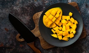 A “hedge-hogged” mango cheek, with cubes of fruit next to it.