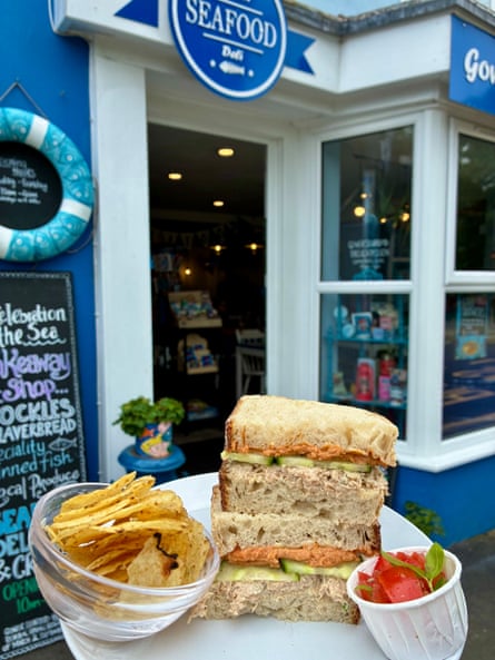 Crab sandwich on tray outside the Gower Seafood Hut & Deli in Mumbles. Restaurant in background
