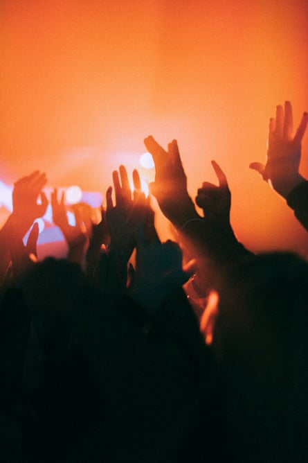 Silhouette raised hands of men and women dancing at nightclub