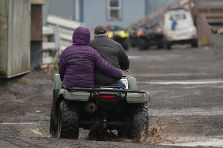 A couple drives through the streets on their ATV in Kivalina, Alaska, a Native coastal village where there are few vehicles.