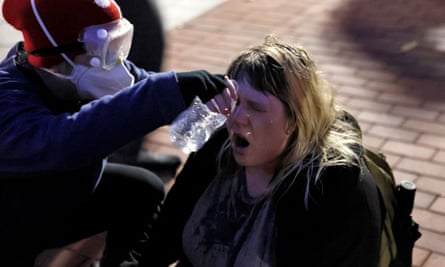 A protester pours water on another protester’s face at Pennsylvania State University in State College, Pennsylvania on 24 October 2022..