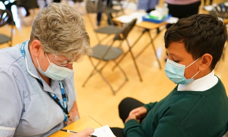 A school pupil speaks with a nurse before he receives his vaccine at the Excelsior Academy in Newcastle upon Tyne.