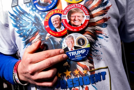 a man wears buttons in support of Donald Trump