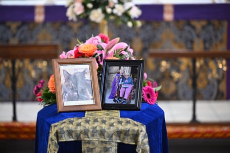 Two photographs sit in a coffin in a church.