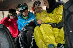 Girls share a joke as they laugh about something on their mobile phone on the way to the mountains.