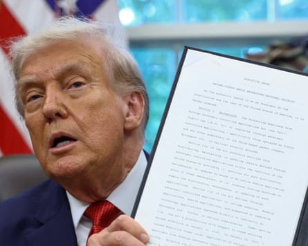 Donald Trump shows a signed executive order on a deal that would divest TikTok's US operations from its Chinese owner, ByteDance