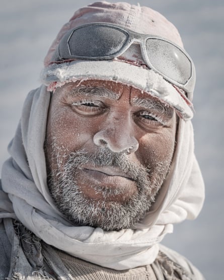 أحد عمال المحجر في المنيا، يرتدي قبعة ووجه مغطى بالغبار الأبيض من الحجر الجيري. ليس لديهم معدات حماية وغالبًا ما يصابون بأمراض الجهاز التنفسي بعد استنشاق غبار السيليكا.