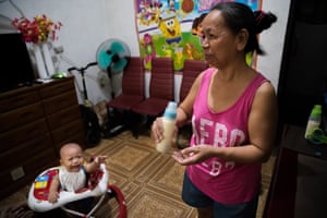 Felicidad prepares formula in her neice’s home for grandson Dashiell in Caloocan city, Metro Manila, the Philippines.