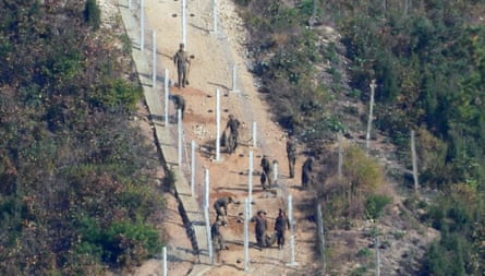 North Korean workers are seen erecting barbed-wire fences at border areas in Hwanghae province on 25 October.