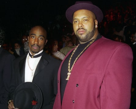 two men, one in a tuxedo, one in a maroon jacket and hat