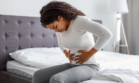 Black woman suffering from stomachache, touching her tummy