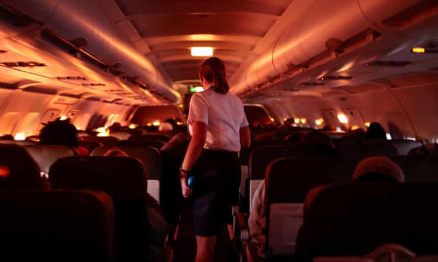 A flight attendant walks through a plane before its descent into Dallas/Fort Worth International airport in November