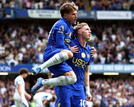 The Chelsea winger Pedro Neto (left) leaps on to the back of his teammate Cole Palmer (right) after Palmer's goal in a 4-3 home Premier League win against Brighton