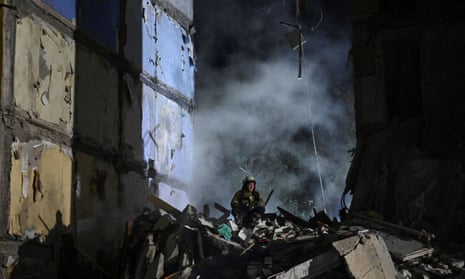 A rescuer at a damaged residential building in Zaporizhzhia after the Russian airstrike