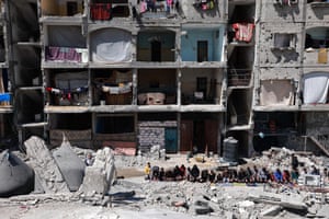 People perform prayers amid rubble
