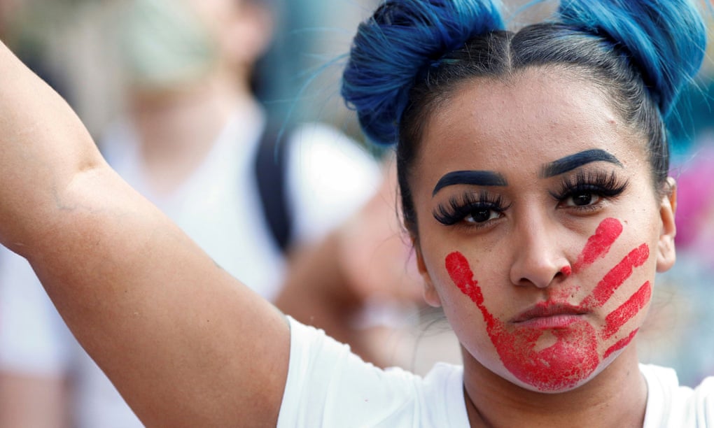 A woman with a red hand painted on her face, which calls attention to the high rates of Indigenous women who are murdered or missing. Photograph: Kevin Mohatt/Reuters