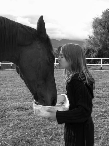 girl kisses horse on its head