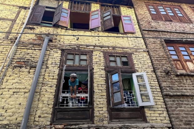 The children of migrant workers from Uttar Pradesh look out from their rented home in Srinagar, in Indian controlled Kashmir