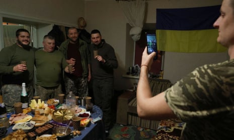 Un soldado ucraniano toma una foto con su teléfono en una casa de descanso militar en la región de Donetsk en la víspera de Año Nuevo.