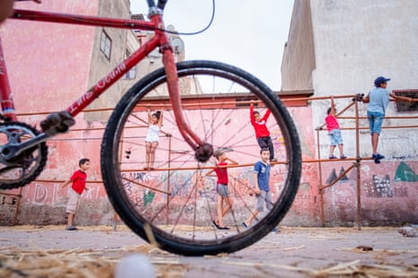 Closeup of a bicycle in the foreground as children climb on a metal structure