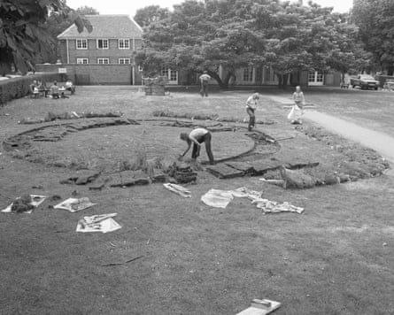 Workers installing David Nash’s Sod Swap, cutting a circular turf pattern on a lawn