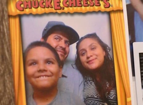 A man, woman and boy smile in a photo framed with Chuck E Cheese