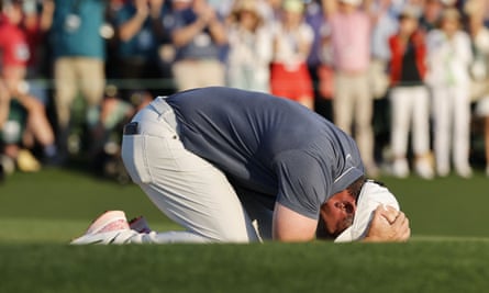 Rory McIlroy on his knees with his head in his hands after his winning putt.