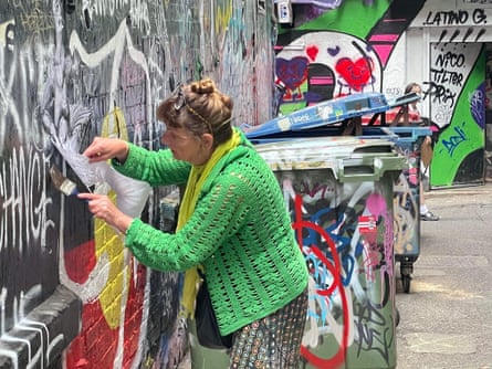 Street artist Deborah Wood stencils a wall