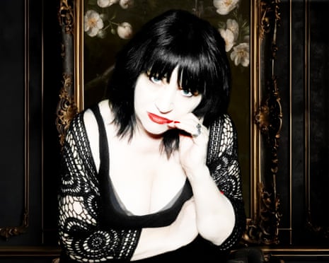 Lydia Lunch posing in front of a gold framed mirror