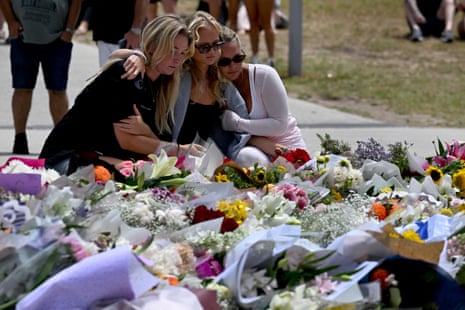 Mourners gather by floral tributes at the Bondi Pavilion