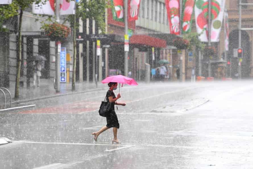 Pedestrians are seen as heavy rain falls in Sydney, Thursday, December 23, 2021.