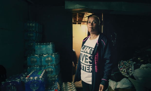 Flint resident Nakia Wakes at home, where she has stored bottled water for her family.