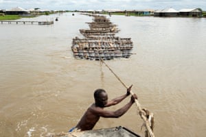 Elewuro, the captain of the tug boat, controls the line of rafts behind him