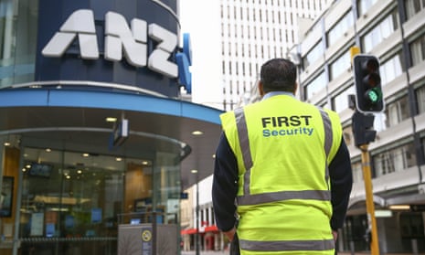 security guard in hi-viz stands outside an ANZ bank in Wellington, NZ