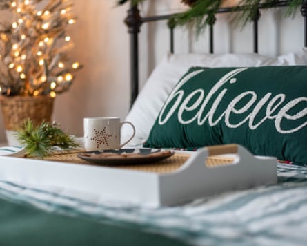 A cosy holiday bedroom with hot tea and cookies on a tray