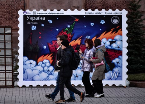 Residents of Kyiv walk past a mock-up stamp depicting the burning of Moscow’s Kremlin.