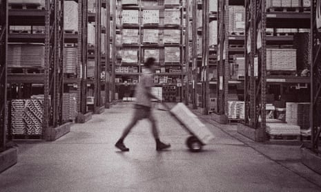 A warehouse worker pushes a hand truck.