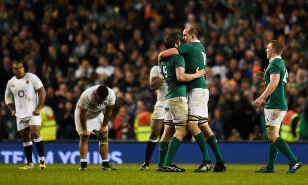 Ireland’s Iain Henderson and Devin Toner celebrate at the end of the match as England’s dejected players look on.