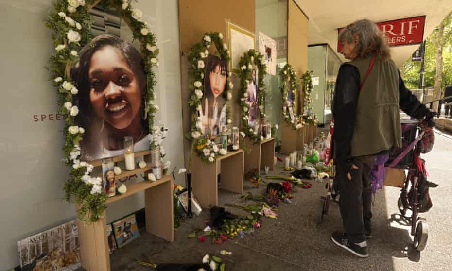 A woman pauses by a memorial. Enlarged pictures of the victims of Sunday's shooting are set on small stands and surrounded by flowers and candles.