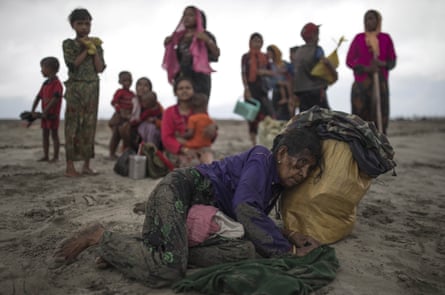 An elderly Rohingya woman collapses, after the wooden boat she and her companions were travelling on from Myanmar crashed into the shore, in Dakhinpara, Bangladesh.