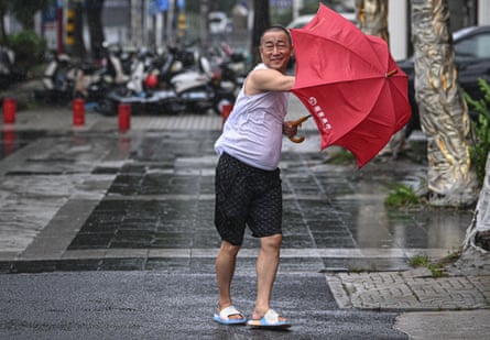 A pedestrian walks against wind on a street in Haikou in south China’s Hainan province