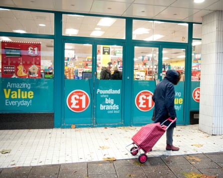 A woman pulling a shopping trolley passed Poundland in Canterbury, Kent