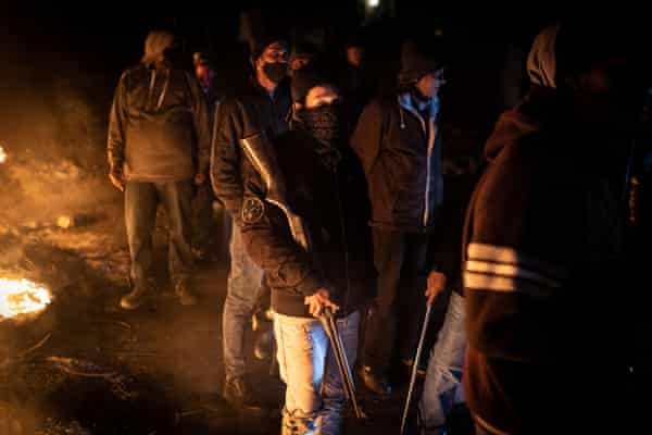 Community members hold weapons as they stand at a roadblock in Phoenix township, north Durban.