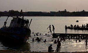 People swim in the Shatt al-Arab waterway in Basra to beat the heat
